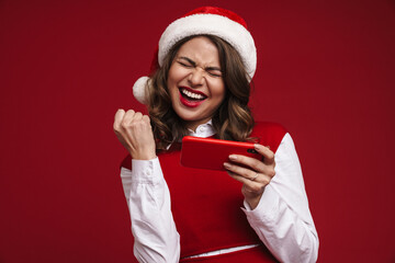 Wall Mural - Positive young woman in christmas santa hat