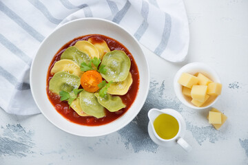 Poster - Bowl of italian ravioli with tomato sauce and grated parmesan cheese, flatlay on a white concrete background, studio shot