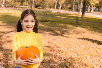 Canvas Print - Cute little girl with pumpkin in autumn park