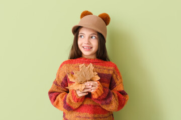 Canvas Print - Cute little girl with autumn leaves on color background