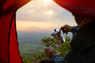 Wall Mural - View from inside the tent,Tourists pouring coffee from mocha pot, coffee, tents and beautiful nature.