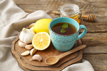 Cup of healthy garlic tea on table