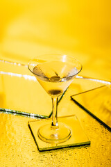 Wall Mural - green olive in glass of martini on yellow