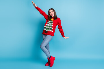 Full size photo of cool girl in christmas tree decor sweater pullover dance x-mas discotheque isolated over blue pastel color background