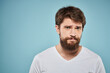 © SHOTPRIME STUDIO - Bearded man emotions white t-shirt lifestyle gestures with hands blue backgrounds
