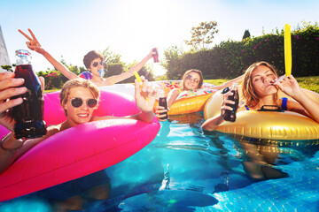 Wall Mural - Many happy children party, drink cola and blow noisemakers in swimming pool