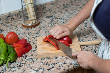 Wall Mural - close up of a women chopping a red pepper. cooking healthy vegetables