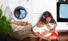 Little Beautiful Girl Washes And Plays With Kitten B, She Dries Him With A Towel After Washing. The Child Sits On The Floor Near The Washing Machine. Banner. Long Format. High Quality Photo