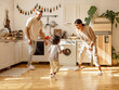 © JenkoAtaman - Energetic multiracial family playing in kitchen.