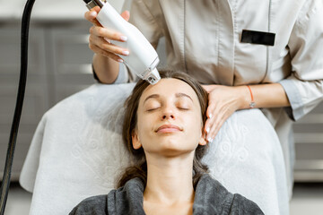 Portrait of a young woman during a facial rejuvenation treatment at medical SPA. LaseMD procedure concept