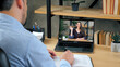 © viacheslav - Smiling woman tutor teacher in laptop screen greets teaches by remote web cam, distance education. Man student studying at home office online by conference video call computer, writes in notebook