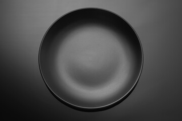 Wall Mural - Empty black plate on a dark gradient background