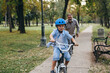 © cherryandbees - boy teaching to ride bike with his grandfather in public park