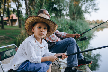 Wall Mural - boy fishing with his grandfather by the lake