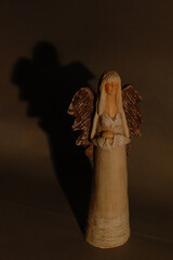 Poster - Vertical shot of an angel small statue in a dark room