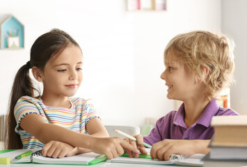 Sticker - Little boy and girl doing homework at table indoors