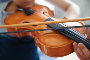 Canvas Print - Young woman teaching little boy to play violin indoors, closeup