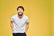 © SHOTPRIME STUDIO - Man gesturing with hands emotions lifestyle white t-shirt yellow isolated background