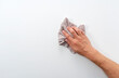A man's hand on a white background with a rag