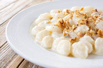 Wall Mural - A view of a plate of gnocchi, in a restaurant or kitchen setting.