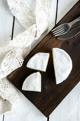 Wall Mural - A type of Brie cheese. Camembert cheese. Fresh brie cheese and slice on a wooden board. Italian, French cheese. view from above