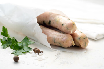 Traditional homemade chicken sausages wrapped in paper with pepper and herbs