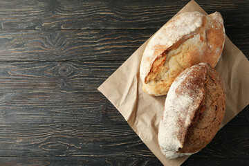 Baking paper with fresh bread on wooden table