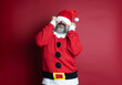 © jcalvera - Caucasian bearded man with Santa Claus is too big a hat for him. Isolated on red background