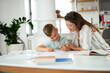© JustLife - Mother helping her son with homework at home. Little boy learning at home..