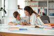 © JustLife - Mother helping her son with homework at home. Little boy learning at home..