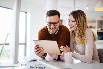 Wall Mural - Beautiful couple working on a tablet at home