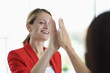© Тихон Купревич - Businesswoman smiles and gives five to her colleague. Successful business career building for women concept