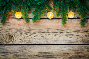 Wall Mural - Burning tea lights amongst fir tree branches on a rustic wooden board.