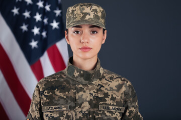 Wall Mural - Female American soldier and flag of USA on dark background. Military service
