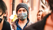 © Mirko Vitali - Urban crowd of citizens walking on city street wearing face mask - New normal reality lifestyle concept with people on worried alienated mood - Selective focus on man with hat - Warm contrast filter