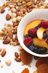 Wall Mural - delicious granola with nuts, berries and fruits in bowl on white