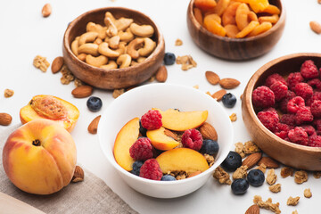 Wall Mural - delicious granola with nuts and fruits on white background