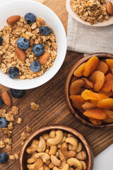 Canvas Print - top view of delicious granola with nuts, blueberry and dried apricots on wooden board