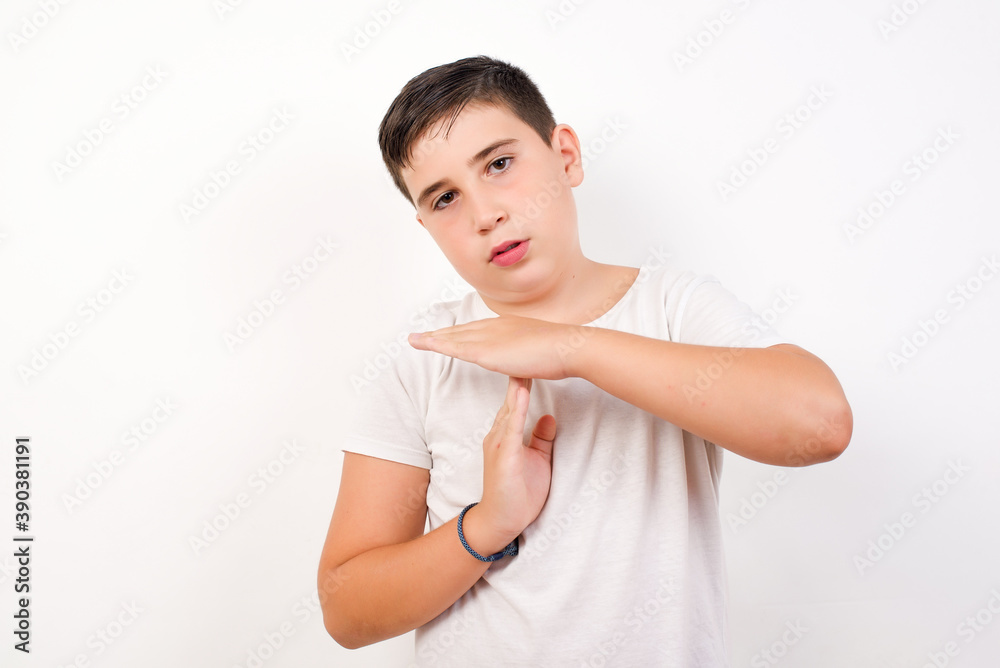 Caucasian young boy standing against white background feels tired and ...
