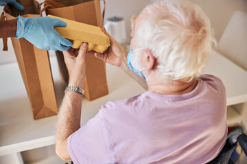 Wall Mural - African American caregiver providing food for an elderly person