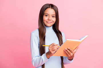 Sticker - Portrait of attractive cheery content brainy girl writing notes copybook diary isolated over pink pastel color background