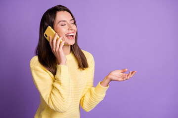 Sticker - Photo portrait of woman talking over yellow mobile phone laughing holding blank space in hand isolated on vivid violet colored background