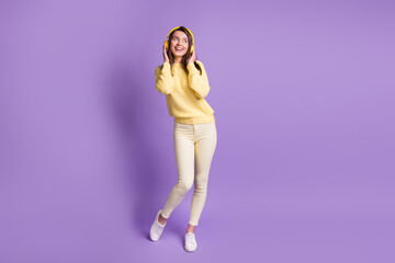 Sticker - Full length body size photo of dreamy brunette listening to music wearing modern yellow headphones smiling isolated on vivid violet color background