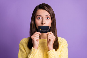 Sticker - Photo portrait of afraid worried girl staring hiding lips below bank credit card wearing yellow sweater isolated on bright purple color background