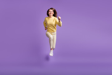 Wall Mural - full length photo portrait of girl jumping up running forward to camera isolated on vivid violet col