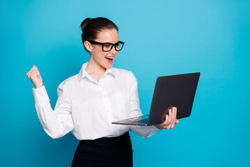 Poster - Portrait of nice skilled cheerful expert girl holding in hands laptop celebrating isolated over bright blue color background