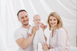 © spaskov - A young Caucasian family with a newborn baby daughter in the bedroom. White light home interior.