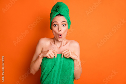 Obraz na płótnie Photo of young cute lady shocked face arms hold falling towel wear green turban isolated orange color background