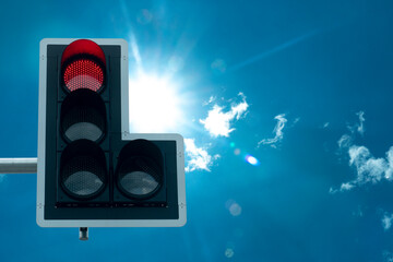 Traffic signal boards that appear red lights to stop. under background of blue sky with sunlight.