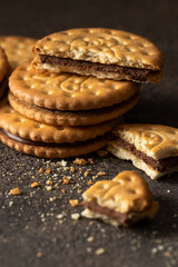 Wall Mural - Sandwich biscuits cookies with chocolate filling on dark background. Crackers with cream